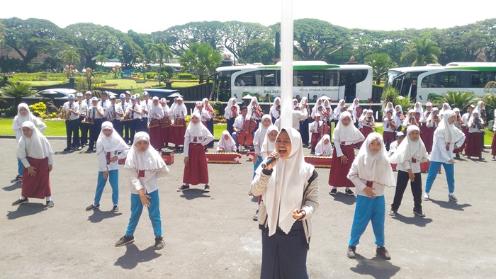 Puluhan siswa siswi SD - SMA tetap semangat di bawah terik panas matahari, berekspresi dan serius menari bernyanyi sekaligus memainkan alunan musik, di halaman Balaikota Malang, Senin (30/4). Foto: IWAN I/BANGSAONLINE