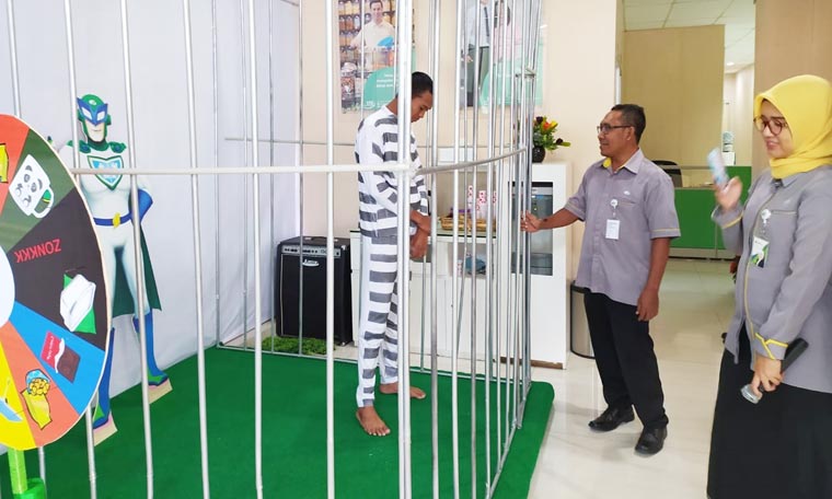 Ada sebuah jeruji besi yang di dalamnya terdapat seorang tahanan di kantor BPJS Ketenagakerjaan Jember.