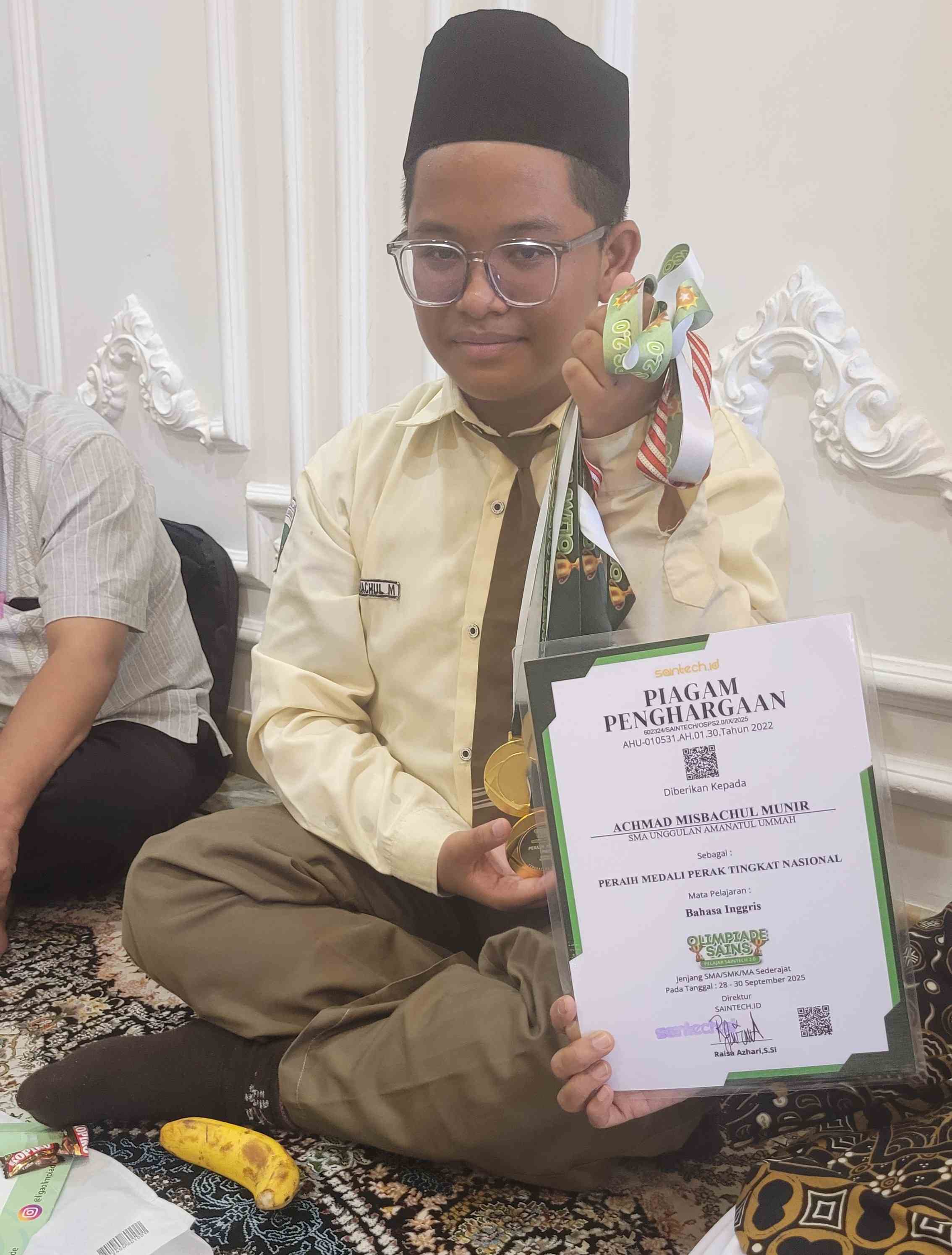 Achmad Misbachul Munir memegang piagam penghargaan yang telah diraihnya. Foto: bangsaonline