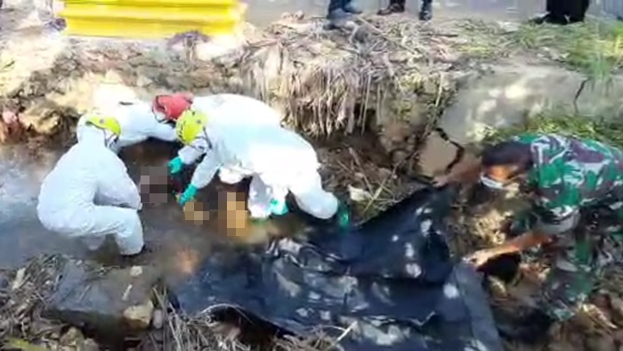 Petugas sedang mengevakuasi jasad korban dari sungai.