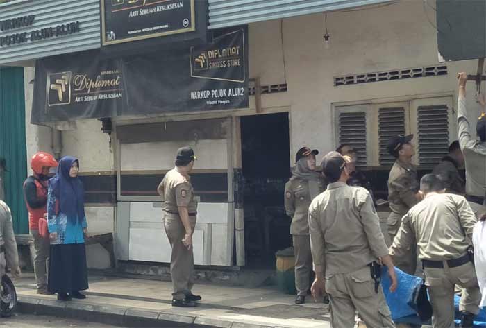 Kepala Dispol PP Achmad Nuruddin bersama pejabat Muspika Gresik saat menertibkan warkop di Jalan Malik Ibrahim. foto: SYUHUD/ BANGSAONLINE