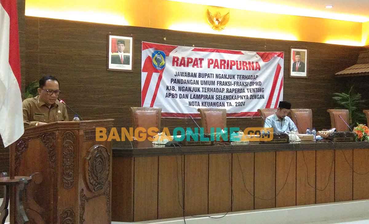 Sekdakab Nganjuk, Nur Solekan, saat membacakan jawaban pj bupati atas pandangan umum fraksi-fraksi. Foto: BAMBANG DWI JULIANTO/BANGSAONLINE 