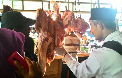 Petugas saat memeriksa daging busuk di Pasar Ngaglik Kelurahan Ngadisimo kota Kediri. (foto: arif kurniawan/BANGSAONLINE)
