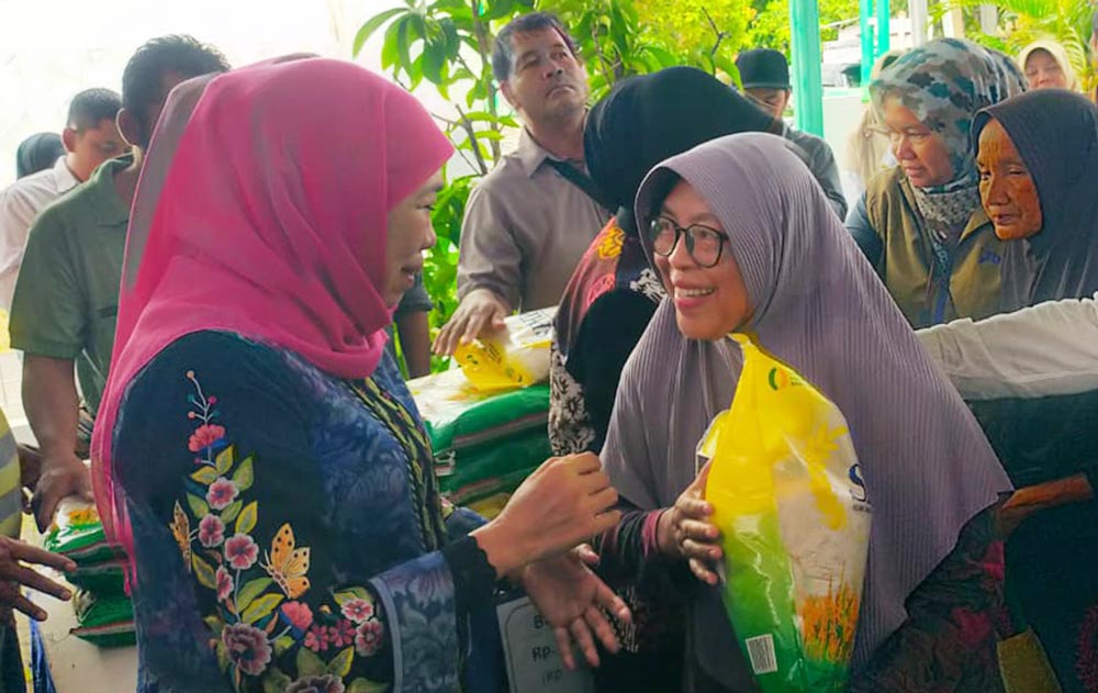 Gubernur Jatim Khofifah Indar Parawansa turut melayani warga yang berbelanja sembako di Pasar Murah.