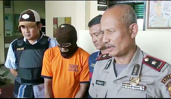 Kapolsek Kepanjen Kompol Bindriyo saat memberikan keterangan persnya. Tampak pelaku S dikait petugas.