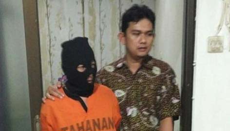 Ahli rukyah abal-abal alias Gus Aji didamping petugas. foto: beritajatim