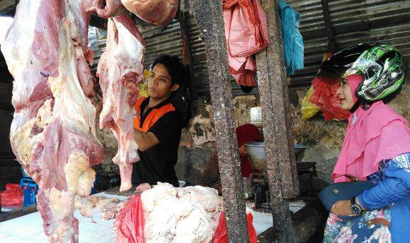STOK AMAN: Seorang penjual daging sapi di Pasar Krian Sidoarjo, tengah melayani pembeli, Sabtu (11/6). foto: MUSTAIN/ BANGSAONLINE