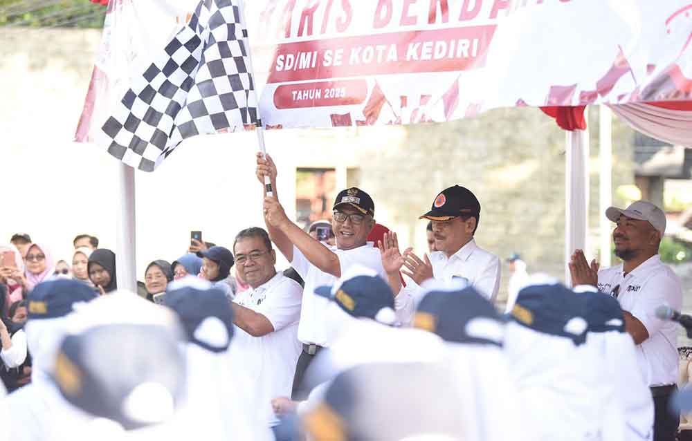 Wakil Wali Kota Kediri Qowimuddin (mengibarkan bendera) saat memberangkatkan peserta lomba baris tingkat SMP/MTs. Foto: Ist. 