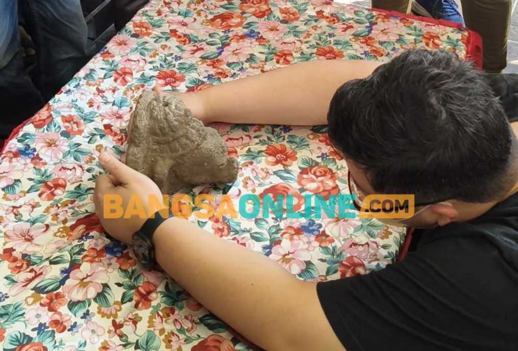 Bupati Kediri Dhito saat memegang arca Fragmen Kepala Ganesha yang sudah kembali lagi. Foto: Muji Harjita/BANGSAONLINE.com