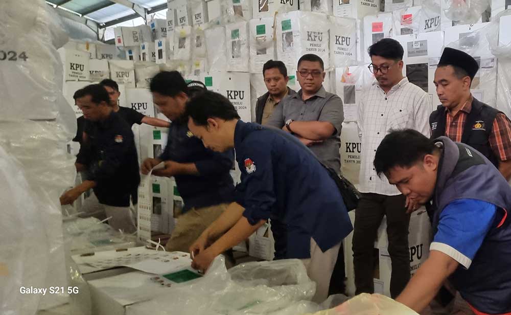 Petugas saat mengecek kotak surat suara sebelum dipindahkan dari Gedung Bulog ke Hotel Double Tree Surabaya untuk dihitung ulang. Proses pengecekan dan pemindahan kotak suara diawasi oleh Bawaslu dan perwakilan parpol. 