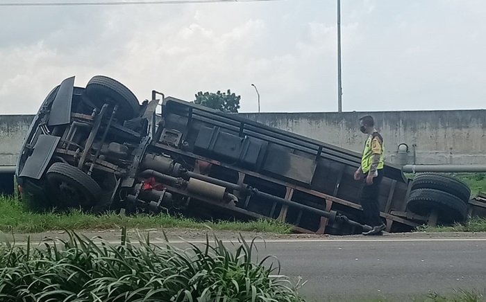 Kondisi truk fuso terguling dan masuk ke parit di ruas Jalan Raya Arteri, Wunut, Porong, Sidoarjo.