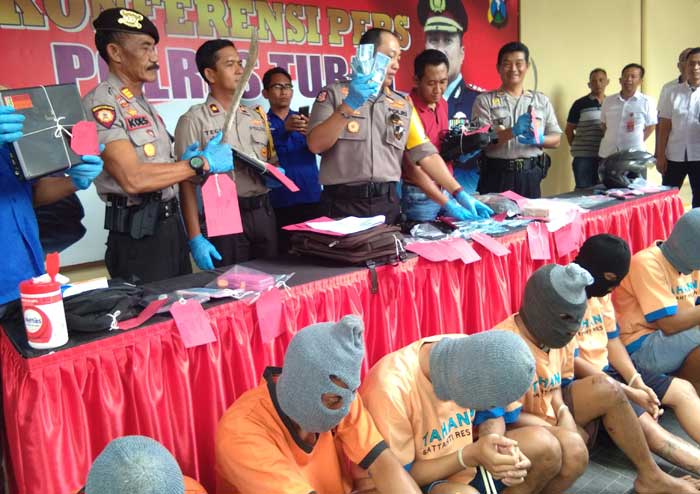 Kapolres Tuban AKBP Nanang Haryono menunjukkan lembaran uang hasil kejahatan tersangka. foto: GUNAWAN/ BANGSAONLINE