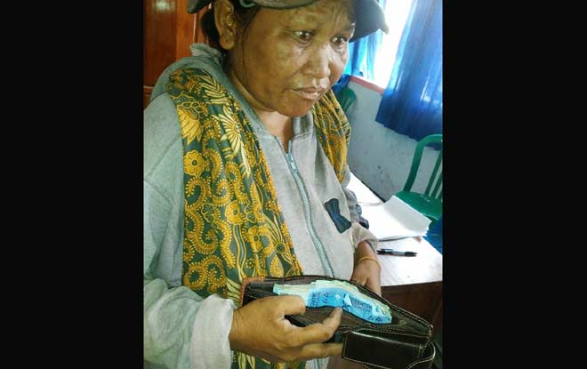 Seorang pengemis menunjukkan dompet yang berisi uang saat diperiksa di Mako Satpol PP Kota Kediri. 