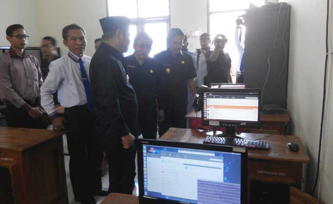 SIDAK UN - Bupati Sidoarjo H Saiful Ilah melihat komputer cadangan yang dipakai UNBK saat sidak Ujian Nasional (UN) di SMK Senopati, di Desa Betro Kecamatan Sedati, Sidoarjo, Senin (4/4). foto: BANGSAONLINE/musta