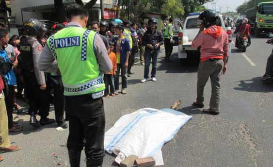 MENGENASKAN - Pelajar korban tewas akibat terlindas truk sebelum dievakuasi petugas ke rumah sakit. (gunadhi/BANGSAONLINE)
