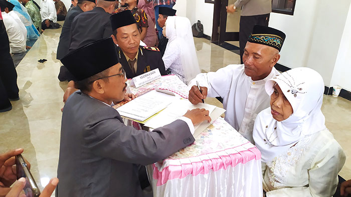 Sepasang kakek nenek saat ikuti nikah massal di Polres Jombang.