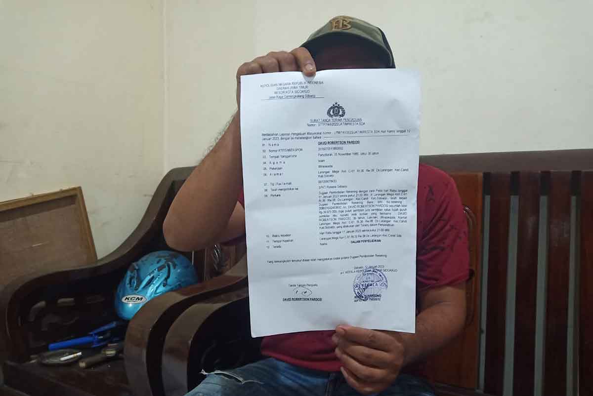 Korban saat menunjukkan bukti laporan dari Polresta Sidoarjo, Selasa (17/1/2023)