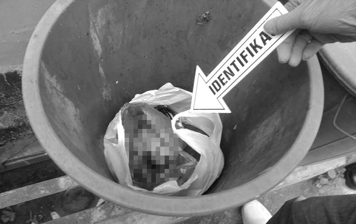 Petugas saat mengevakuasi jenazah bayi di tong sampah.