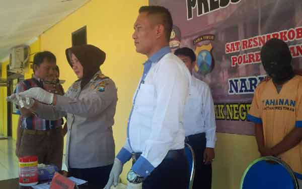 Petugas saat menunjukkan baranag bukti beserta pelaku di Mapolres Tuban. (wan/rvl)