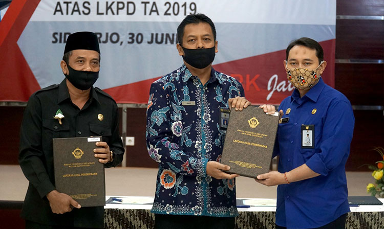 Bupati Nganjuk, Novi Rahman Hidayat saat menerima penghargaan WTP dari Kepala BPK Provinsi Jatim. (foto: BAMBANG/ BANGSAONLINE)