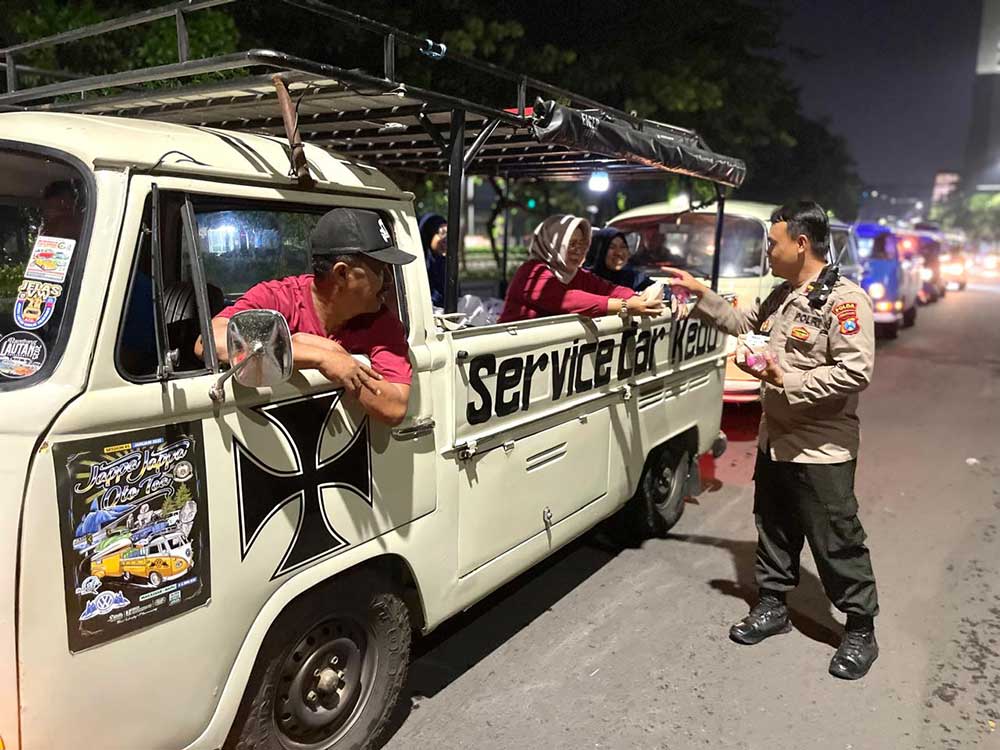 Salah satu dari komunitas pecinta mobil VW saat membagikan paket beras dan nasi bungkus. (Ist)