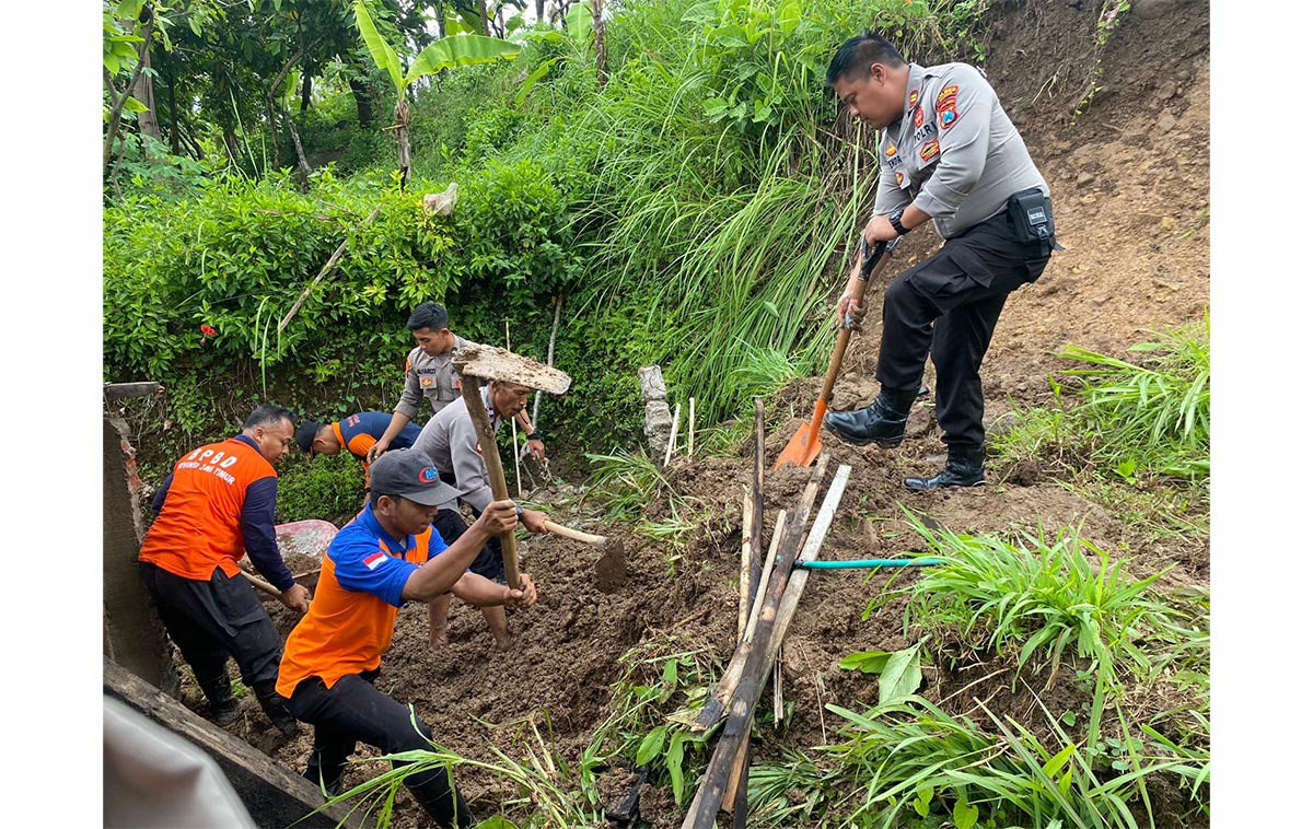 Personel Polres Madiun bersama warga dan instansi terkait membantu membersihkan material longsor. Foto: Dok. Humas Polres Madiun.
