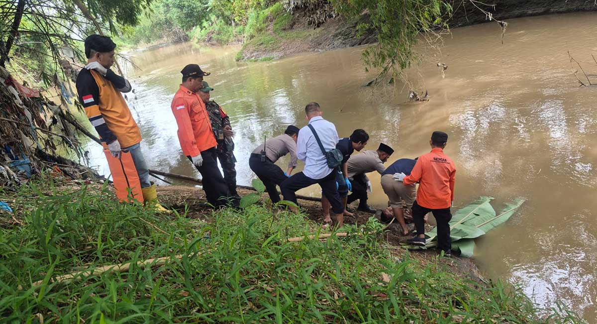 Petugas saat mengevakuasi jenazah di Sungai Pancir Jombang.