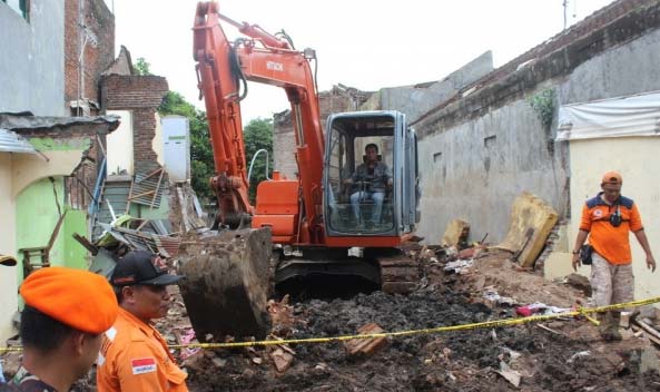 Petugas menggunakan alat berat saat mengevakuasi puing bangkai pesawat Super Tucano TT-3108 yang jatuh di Malang. foto: merdeka