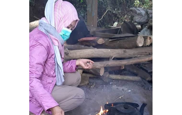 Salah seorang warga Songgokerto saat merebus air di ceret ireng untuk membuat kopi.