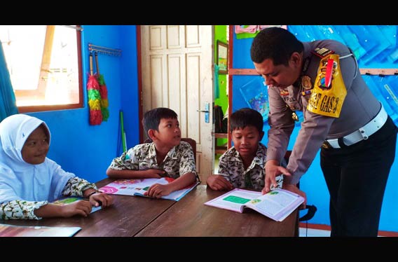 Seorang petugas kepolisian menggantikan guru mengajar di kelas.