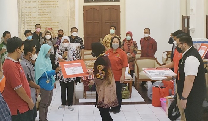 Menteri Sosial (Mensos) Tri Rismaharini didampingi Bupati Kediri Hanindhito Himawan Pramana saat menyerahkan bantuan Atensi kepada salah satu penerima manfaat. foto: MUJI HARJITA/ BANGSAONLINE