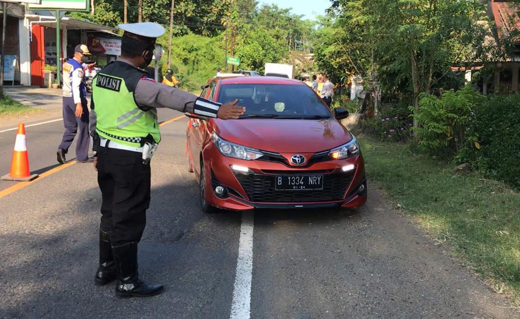 Petugas di pos penyekatan menghentikan kendaraan yang hendak masuk Blitar Raya.