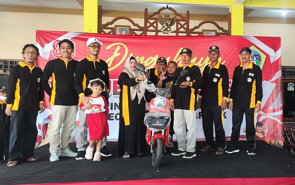 Kades Sembunganyar, Khobir (tiga dari kanan), menyerahkan hadiah motor listrik kepada pemenang undian. Foto: Ist.