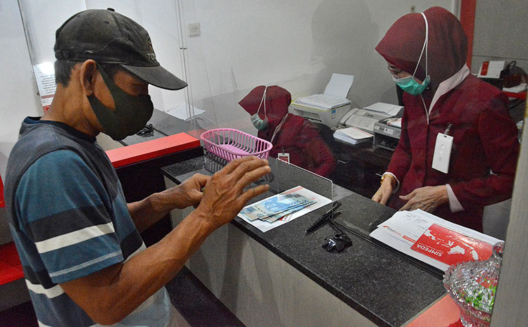 Petugas Bank Jatim saat sedang melayani penerima Kartu Sahabat. (foto: ist)