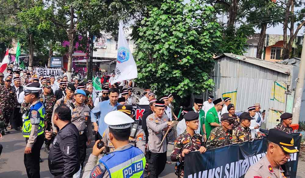 Kapolres Kediri Kota AKBP Anggi Saputra berbaur dengan para santri untuk melakukan longmarch menuju kantor Pemkab Kediri. Foto: Muji Harjita/Bangsaonline.