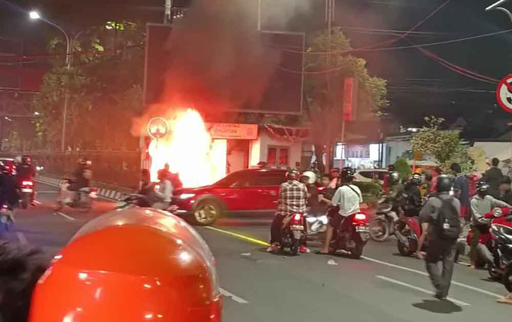 Massa aksi saat membakar pos polisi di Jalan Panglima Sudirman, Surabaya.