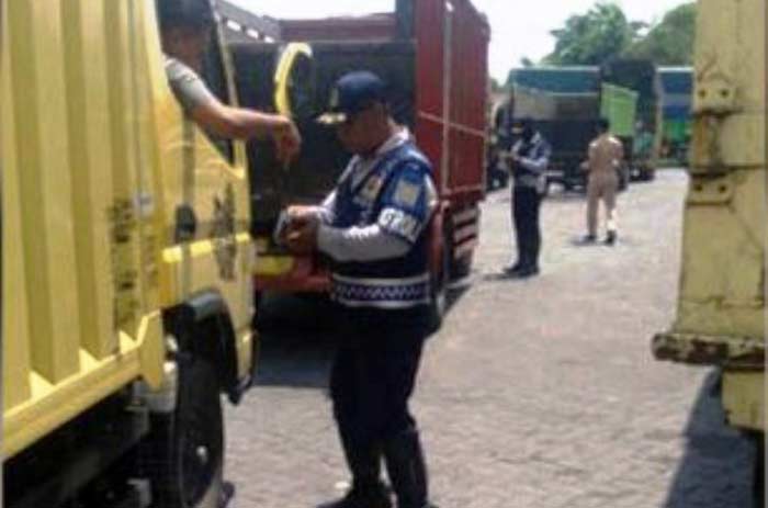 Seorang petugas sedang menanyakan kelengkapan surat kendaraan dalam operasi gabungan di Beji Pasuruan.