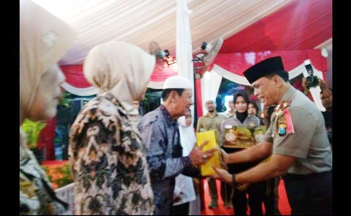 Wakapolda Jatim Brigjend Pol Widodo Prihartopo saat menyerahkan bingkisan. Foto: SYUHUD A/BANGSAONLINE.