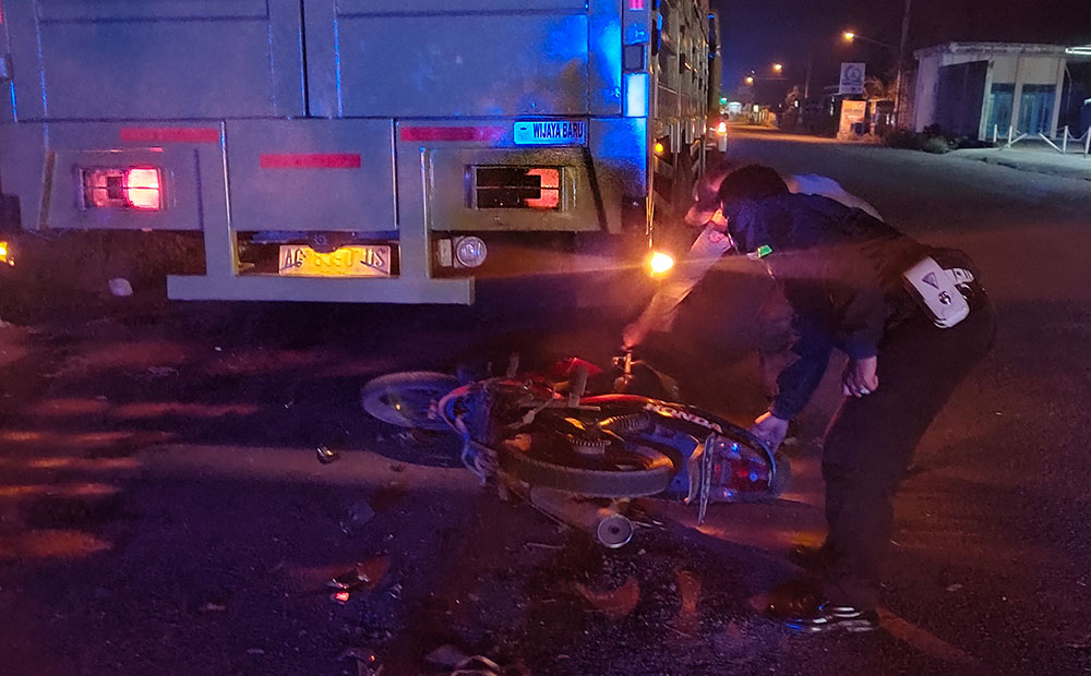 Petugas saat mengevakuasi sepeda motor dari kolong truk tronton untuk dibawa ke Mapolsek Pagu. foto: MUJI HARJITA/ BANGSAONLINE