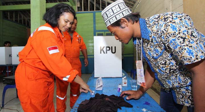 Salah satu pekerja menyelupkan jari ke tinta tanda usai mencoblos.