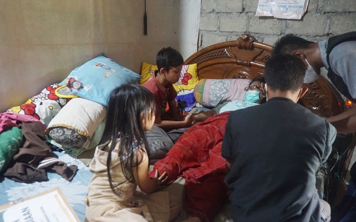 Tim Medis ACT Kediri saat memeriksa kondisi kesehatan ibunda Aldi dengan disaksikan oleh Aldi sendiri dan adiknya. foto: ist.