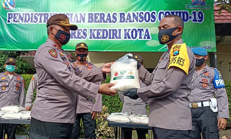 Kapolsek Mojoroto AKP Sartana (kiri) saat menerima bantuan beras secara simbolis dari Kapolres Kediri Kota, AKBP Miko Indrayana. foto: muji harjita/ bangsaonline.com