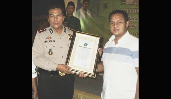 Kapolsekta Sidoarjo Kompol Naufil Hartono menyerahkan penghargaan kepada Bripka Dwi Priyo Sudomo, di Perum KNV Sidoarjo, Minggu (24/7) malam. foto istimewa
