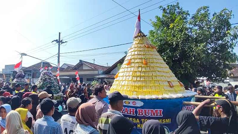 Tumpeng tahu kuning dan hasil bumi sebelum diperebutkan warga. Foto: Muji Harjita.