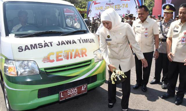 Gubernur Jawa Timur Khofifah Indar Parawansa memecahkan kendi sebagai tanda peluncuran 30 unit mobil samsat keliling cettar di Surabaya, Senin (7/10/2019). Dari 30 unit mobil ini akan ditambah sampai 80 unit mobil. foto: istimewa