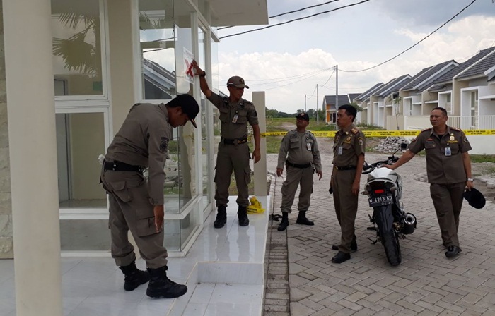 Petugas Dispol PP ketika menyegel perumahan PT. Patra Raya Cerme. foto: SYUHUD  A/ BANGSAONLINE
