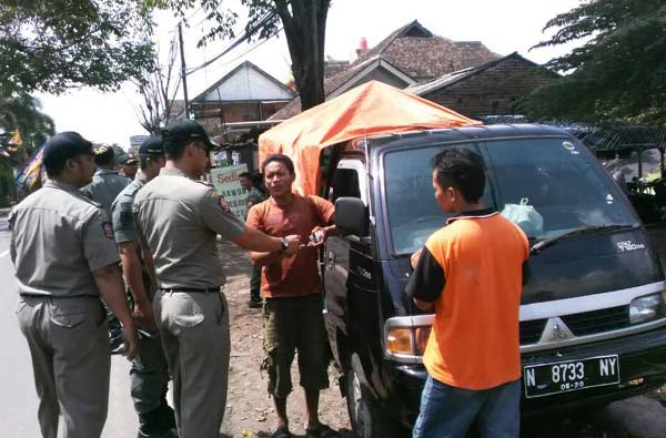 Petugas Satpol PP Pasuruan saat menertibkan salah satu PKL yang menggelar lapaknya dengan mobil. foto: HABIBI/ BANGSAONLINE