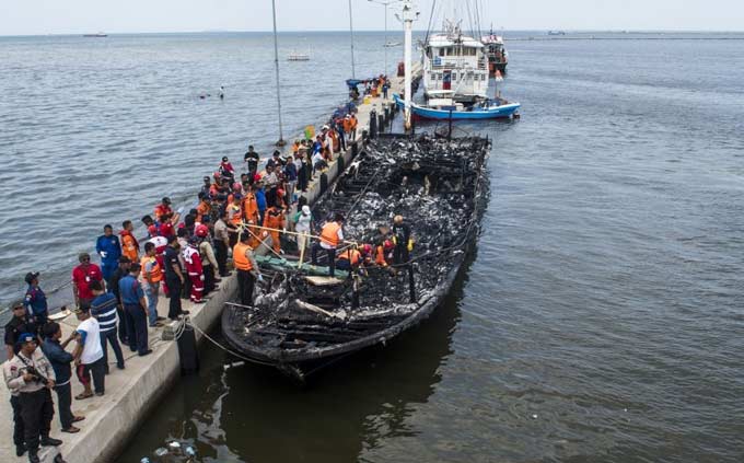 Petugas gabungan mengevakuasi korban yang terbakar di dalam kapal motor Zahro Express di dermaga Muara Angke. foto: Republika