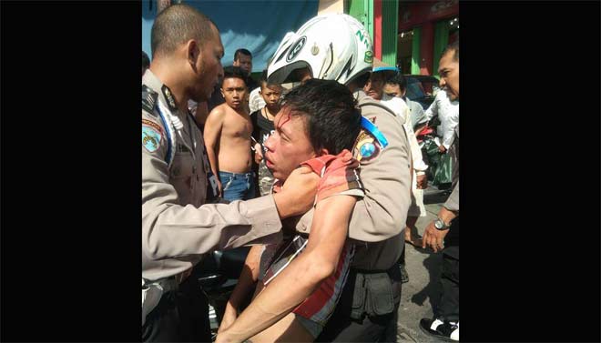 Tersangka Jakfar (28), ketika diamankan polisi saat dihajar massa. foto: istimewa