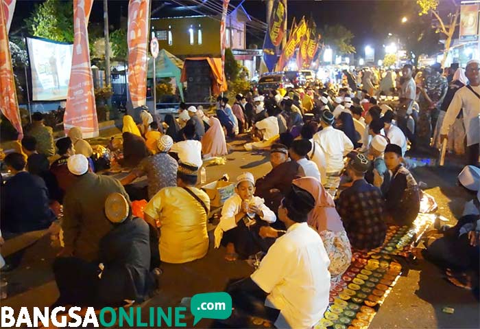 Jemaah yang tidak kebagian tempat di Haul Gus Dur ke-9 terpaksa duduk di jalan raya Jombang-Kediri. foto: RONY S/ BANGSAONLINE